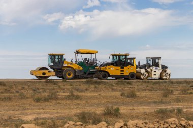 Atyrau, Kazakistan (Kazakistan), 11.05.2025 - Inderbor-Atyrau karayolu üzerinde asfalt döşemek için yol ekipmanı pateni. Kazakistan 'da yeni yollar inşa ediliyor. Asfalt şehirlerarası yollarda yatıyor.