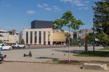 Uralsk, Kazakistan (Kazakistan), 30.05.2025 - Uralsk şehrinde adı Khadisha Bukeeva olan Kazak Tiyatrosu 'nun arka planına dikilmiş genç bir ağaç.