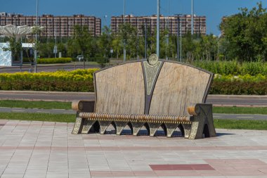 Astana 'daki Merkez Cami Meydanı' ndaki dekoratif bir bank. Yeşillik ve konut binalarına karşı..