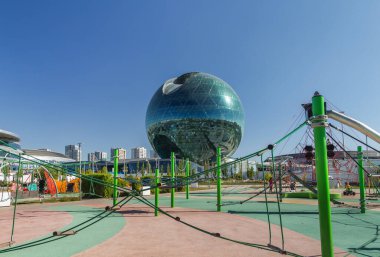 Astana, Kazakistan (Kazakistan), 21 Temmuz 2025 - Astana 'daki Uluslararası Yapay Zeka Merkezi. Modern küresel bina, eski Nur-Alem pavyonu EXPO 2017 'de, modern bir çocuk parkının arka planına karşı..