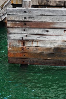 Wooden buffer stop in the Circular Quay of the City Harbor showing white painted hand notations of measurements for the adjacent waterways crisscrossing the whole bay. Sydney-New South Wales-Australia