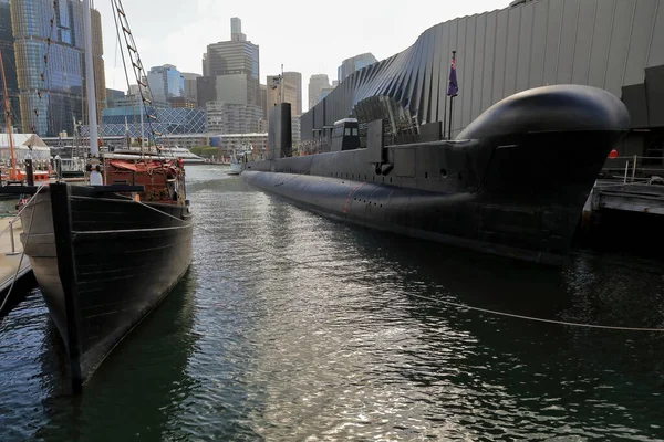 stock image Submarine and wooden fishing trawler on display at the wharf outside the Australian National Maritime Museum-nowadays out of service and preserved as museum ships. Darling Harbour-Sydney-NSW-Australia