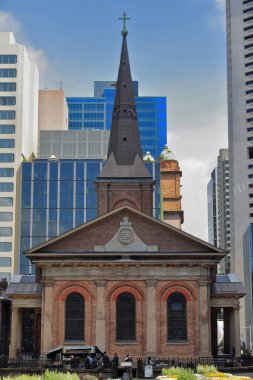 MS 1820 'de inşa edilen, miras listesindeki Saint James Anglikan kilisesi, Macquarie Str.cephesi modern yüksek gökdelenler tarafından desteklenmektedir. Duvardaki delikli kahve dükkanındaki kazara insanlar. Sydney-NSW-Avustralya. OLACAK, NON İÇİN İNSANLARI İSTİYOR.