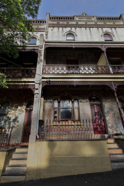 Viktorya dönemi Filigran tarzında iki dikey sarsıcı teras evi. Dikey olarak dantelli demir perdelerle süslenmiş verandaları var. Ormond Caddesi, Paddington. Sydney-NSW-Avustralya.