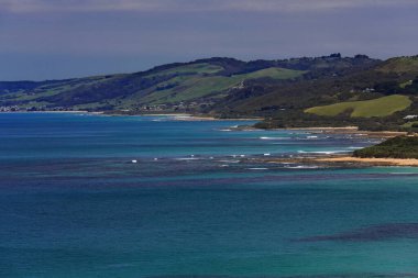 Bass Boğazı-Güney Okyanusu 'ndaki Colac Otway Shire kıyısı boyunca kuzeydoğu-güneybatı manzarası ile merkez ve sol arka planda Skenes Creek kasabası ve Apollo Bay kasabası. Victoria-Avustralya.