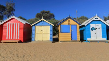 Dendy Caddesi Plajı 'ndaki 82 renkli Viktorya dönemi hamamböceklerinden birkaçı öğleden sonra W.ile Port Phillip Körfezi' ne bakan kereste yapıları Brighton Beach Banliyösü 'nde görülüyor. Melbourne-VIC-Avustralya.