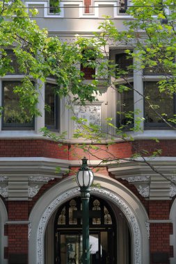 Kırmızı tuğlada Romanesk tarzı merkez dairesel giriş ve MS 1908 'den kalma Collins Caddesi' nin kuzeyindeki tarihi miras binasının çimento cephesi. Melbourne-VIC-Avustralya.