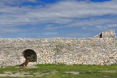 Kala Kalesi 'nin kuzeybatısındaki taş duvarın kalıntıları. Osum Nehri' nin kuzey kıyısına bakan tepenin tepesinde. Boşluktaki eski top. Berat-Arnavutluk.