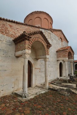 SW cephesi, kilisenin gable-çatılı kapıları -katholik- Aziz Mary Manastırı 'nın sütunları, Roma heykellerinin başkentlerinin taçlandırdığı çiçek motifleri. Apollonia-Arnavutluk.