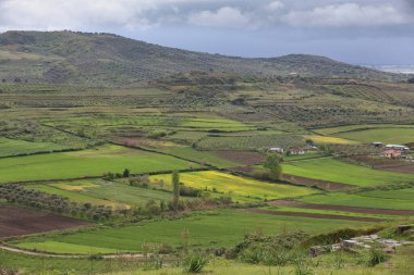 Antik duvarların yıkıntıları üzerine SW-ward manzarası - 4 km uzunluğunda, 2-3.5 m kalınlığında, devasa taş bloklardan çevresindeki tepecikli tarım arazilerine kadar. Apollonia-Arnavutluk.