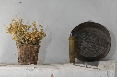 Ev dekoru: 1700 'lerin başında bir Osmanlı evinde, el yapımı hasır sepetteki kuru kenevir veya demir uçlu çiçekler, eski Türk usulü pirinç kahve öğütücüsü ve demir pişirme tavası. Cirokaster-Arnavutluk.