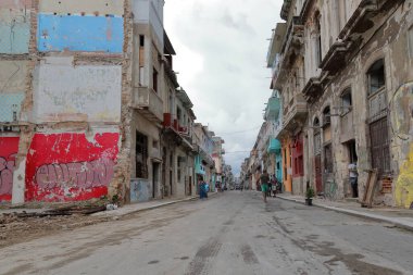 Havana, Küba-8 Ekim 2019: Calle Escobar Caddesi 'nde öğleden sonra erken saatlerde bakımsız ve yerliler iş sonrası sohbet için kaldırımları işgal etmeye başlarken dinlenen evlerle birlikte..