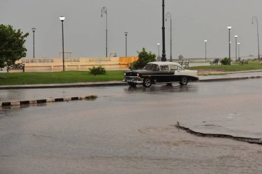 Havana, Küba-8 Ekim 2019: siyah-beyaz Amerikan klasik arabası -almendron- Chevrolet Bel Air dört kapılı Sedan 1956 Jovellar Caddesi 'nden Malecon Geçidi' ne doğru şiddetli bir fırtına altında ilerliyor..