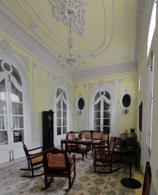 Cienfuegos, Küba-11 Ekim 2019: Eski Palacio Ferrer Sarayı 'ndaki Hall, şimdi Museo de Artes Müzesi, soluk sarı duvarlar ve tavan, beyaz dekoratif pervazlar ve antika ahşap mobilyalar sergilenmektedir..
