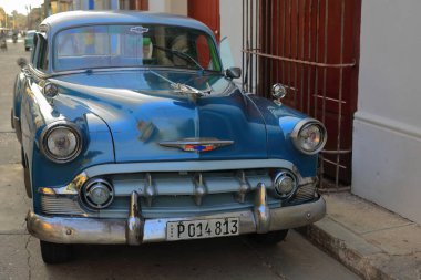 Trinidad, Küba-12 Ekim 2019: Ön manzara, mavi ve beyaz eski Amerikan klasik arabası -almendron, yank tank- Chevrolet Bel Air 4 kapılı Sedan 1953 'ten kalma, Plaza Belediye Başkanı Meydanı civarındaki bir sokakta durdu..