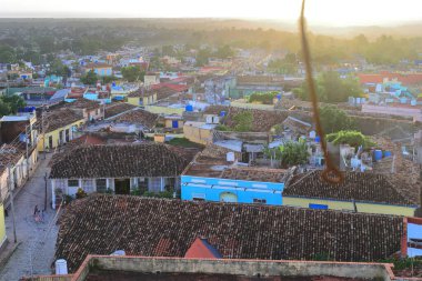Trinidad, Cuba-October 12, 2019: Early sunset, W-wards view from the San Francisco Church belfry over the city's red tile roofs along Boca Street crossed by Real del Jigue Street in Plazuela del Jigue clipart