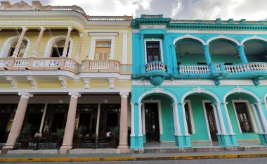 Santa Clara, Küba-14 Ekim 2019: 1900 'lerin başından kalma iki katlı eklektik binaların birinci katındaki büyük balkonların karışımı turkuvaz beyazı ve sarı bej rengini Park Vidal Park' a boyamış..