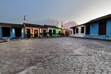 Camaguey, Küba-15 Ekim 2019: 1732 tarihli güney batıya bakan manzara, Plaza San Juan de Dios Meydanı 'nı alacakaranlıktaki Calle Matias Varona Caddesi çaprazındaki koloni binalarına yerleştirdi..