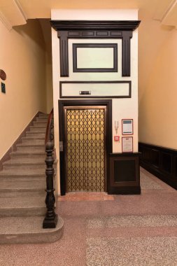 Camaguey, Küba-15 Ekim 2019: Yenilenmiş, modern bir asansörün iki panelli kapıları, tarihi merkezde yenilenmiş bir otelin eski kuyusunu ve eski bir asansörün görünümünü koruyor..