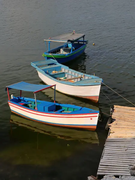 stock image Rowboat and motorboats for fishing moored to a small wooden pier jutting out from the shore of Cayo Granma Key in the southern area of the bay next to its mouth into the Caribbean Sea. Santiago-Cuba.