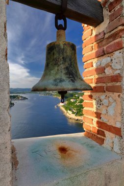 Santiago, Cuba-October 19, 2019: Old bell set into a brick arched steeple, north bulwark of the 1660s built Holy Trinity platform of the 1587 designed Castillo de San Pedro de la Roca del Morro Castle clipart