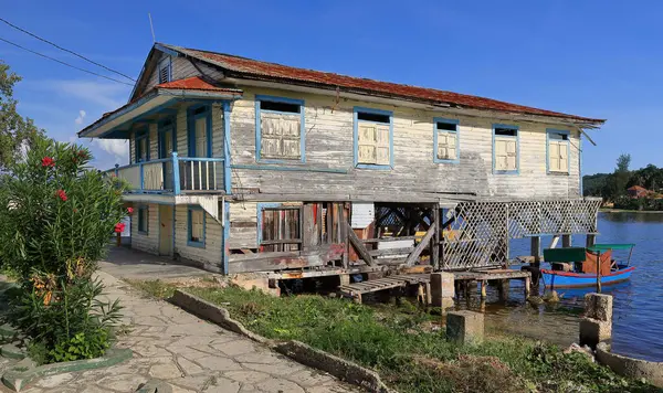 stock image Santiago, Cuba-October 19, 2019: Corrugated sheet metal roofed wood house on timber stilts above the water, vernacular dwelling of the local fishing community, Cayo Granma Key in the south of the bay.