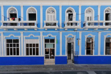 Santiago, Cuba-October 20, 2019: Facade of Eclectic style, three-storey, early 1900s building in azure and light blue on Calle General Lacret -former San Pedro- Street facing the cathedral's east side clipart