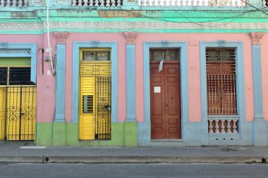 Santiago, Küba-20 Ekim 2019: Açık mavi ve nane yeşili kaplamalı pembe duvar, sarı ve kahverengi kapılı, Calle Francisco Aguilera Caddesi 'nde kuzeye bakan eklektik stil binası.