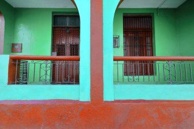 Santiago, Küba, 20 Ekim 2019 Calle Heredia Caddesi 'ndeki tek katlı koloni tarzı evin ön cephesinde nane yeşili ve kestane kırmızısı duvar, ızgara kaplı ahşap kapılar ve pencereler yer alıyor..