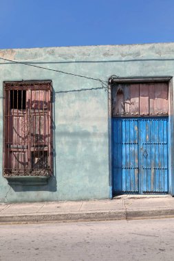 Santiago, Küba-20 Ekim 2019 solmuş nane yeşili cephe ve kırık mavi-pembe kapı ve Corona Caddesi batı yakasındaki bir katlı, terk edilmiş, tek katlı koloni evi, çift sayılı 850 numara alan..