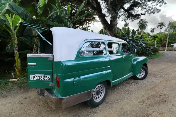 Stock image Baracoa, Cuba-October 22, 2019: White-roofed green American classic utility vehicle -1947 Ford Super Deluxe Station Wagon- for passenger service stationed next to Playa Manglito Beach, Mata community.