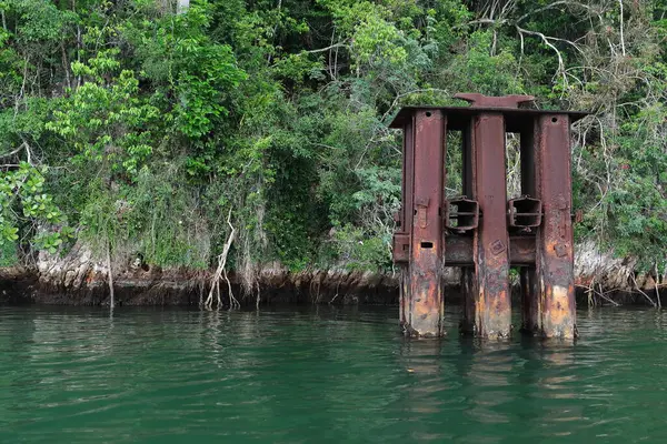 stock image SE shore Bahia Taco Bay, rusty steel remains of a former mooring for ocean-going vessels transporting to the US precious woods extracted in the area by a sawmill working from 1930-1945. Baracoa-Cuba.