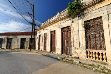 Havana, Küba-24 Ekim 2019: Regla bölgesindeki Calle Santuario Sokağı 'ndaki harap olmuş tek katlı evler, solmuş duvarlar, bozulmuş ahşap kapılar ve paslı ızgara pencereler..