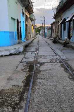 Havana, Cuba-October 24, 2019: Southwestward view from Calle Marti Street along Calle 27 Noviembre Street, Regla municipality, way of the former Hershey Interurban streetcar track going to the harbor. clipart