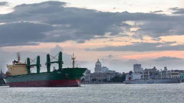 Havana, Cuba-October 24, 2019: View of the urban center and bayside area with oceangoing cargo ships anchored in the harbor, from the Lanchita de Regla Ferryboat going to the Emboque de Luz Boarding. clipart