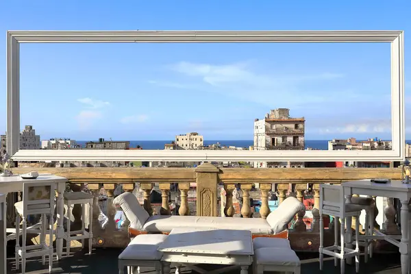 stock image Havana, Cuba-October 25, 2019: A view with a frame, northward view from the renowned La Guarida paladar -family run restaurant- roof terrace over the city rooftops to the Atlantic Ocean horizon line.