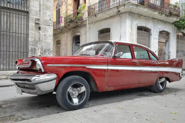 stock image Havana, Cuba-October 26, 2019: Side-front view, white-roofed red American classic car -DeSoto Diplomat 4 door Sedan 1957- parked in front of Calles Brasil and Cristo Streets east corner, Habana Vieja.