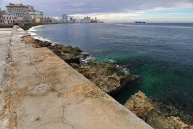Deniz kenarındaki siperlerin ve Malecon Esplanade boyunca sıralanan binaların 65 numaradan uzak arka plandaki ABD Büyükelçiliği 'ne kadar yağışının ardından görüntüler. Centro Havana ve Vedado-Havana-Küba.