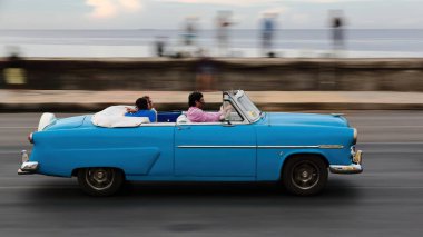 Havana, Küba-26 Ekim 2019 klasik Amerikan arabası Ford Crestline Sunliner 1952 'den kalma üstü açılabilir 2 kapı yerel balıkların dinlenip sohbet ettiği Malecon Güvertesi' nin batısından doğusuna doğru sürüyor..