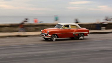 Havana, Küba-26 Ekim 2019: Beyaz çatılı, bakır kırmızısı klasik Amerikan arabası -1954 yılından Chevrolet BelAir 4 kapılı Sedan - E 'den W' ye Malecon gezinti güvertesinde yerel balıkların dinlenip sohbet ettiği yer..