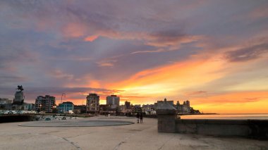 Havana, Cuba-October 26, 2019: Sunset view of the seawall parapet and the buildings in row along the Malecon Esplanade from the Parque Maceo Park area to the Edificio Someillan building. Havana-Cuba. clipart