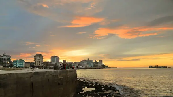 stock image Havana, Cuba-October 26, 2019: Sunset view of the seawall parapet and the buildings in row along the Malecon Esplanade from the Parque Maceo Park area to the Edificio Someillan building. Havana-Cuba.