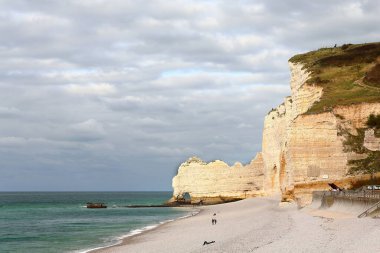 Northeastward view along the beach and the white chalk rock Falaise d'Amont Cliff to the Arche d'Amont Arch, resembling an elephant dipping its trump into the sea. Etretat-Normandie-Normandy-France. clipart