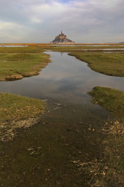 Mont-Saint-Michel, Fransa-19 Ekim 2020: Sabahın erken saatlerinde kuzeybatıya doğru Manastır Ovası 'nın ötesine, gel-git adasına, bulutlu-gri bir gökyüzünün altına yansıyan gelgit göletlerine..