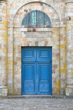 Mont-Saint-Michel, Fransa-19 Ekim 2020: 1776 yangınından sonra yeniden inşa edilen Abbey-Kilise neo-Klasik batı cephesinde mavi ahşap kapılı meydan kapısı, Plomb du Four veya West Terrace 'a dönük..