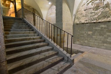 Mont-Saint-Michel, France-October 19, 2020: Stairway descending from the Refectory -building's third level- into the Guests Room -second level- landing, AD 1860 relief depicting Bishop Aubert's dream. clipart