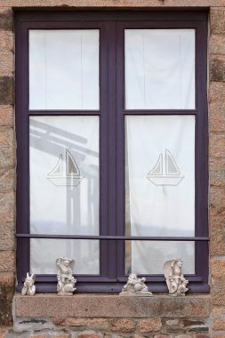 Baş melek Michael ve ejderha, küçük şeytan, gaydacı melek, bir pencere pervazında, ortaçağ binasının arka tarafında Mont Saint Michel 'in surlarına bakan. Normandiya - Fransa