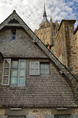 Mont-Saint-Michel, France-October 19, 2020: Wood-shingle and slate clad, rear facade and gable of XV century medieval building on the Grande Rue-Main Street overlooking the patrol path of the rampart. clipart