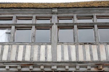 Mont-Saint-Michel, France-October 19, 2020: Glazed upper gallery above the half-timbered facade in white and gray of a medieval building -now a tourist restaurant- overlooking the rampart patrol path. clipart