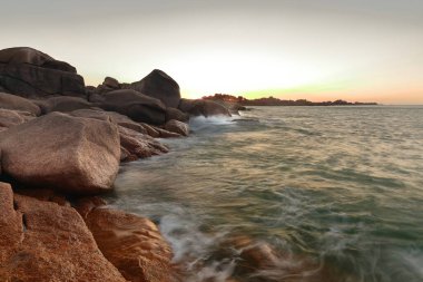 View along the Pink Granite Coast -chaos of stacked rock block heaps of soft, round-angled structures- to the area at the southwest of the Men Ruz -Red Stone- Lighthouse. Ploumanac'h-Brittany-France. clipart